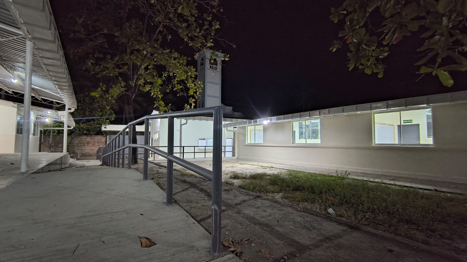 Rampa de acceso inclusivo y fachada nocturna