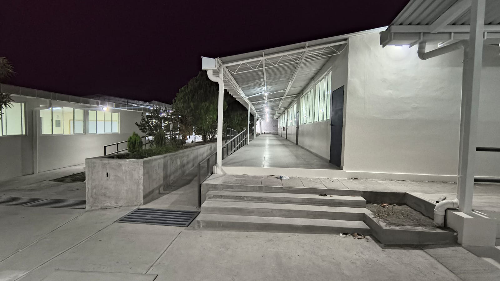 Corredor cubierto y módulo de servicios · noche